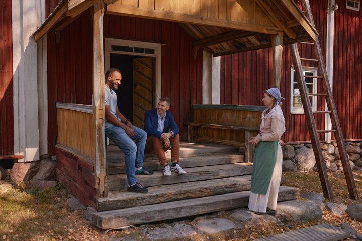 Kolme henkilöä juttelemassa talon kuistilla.