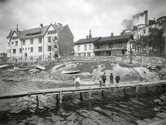 Gustaf Estlanderin ensimmäisen kerrostalon, Berggrundin (1903) ympäristö Eläintarhanlahden pohjoisrannalla oli 1900-luvun alussa rauhallinen, vaikka Hakaniemeen korttelin toiselle puolelle rakennettiin suuria asuin- ja liiketaloja.