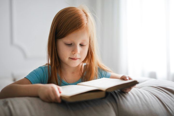 Lapsi lukee kirjaa.