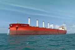 Punainen malminkuljetusalus Sea Zhoushan merellä ja kannella viisi sylinterimäistä valkoista roottoripurjetta