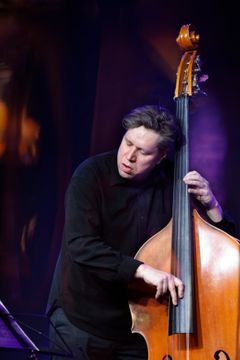 Bassist Antti Lötjönen performing on stage.