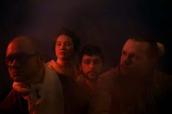 Members of the Josefiina Vannesluoma & Mortal Lease band photographed in reddish lighting