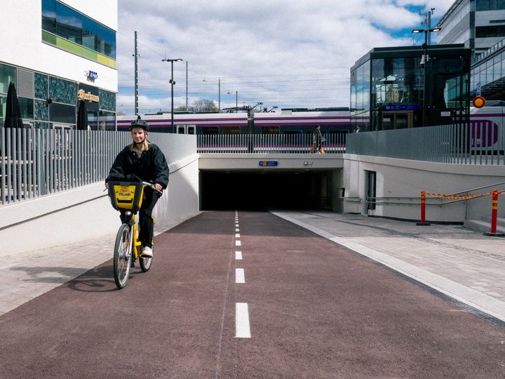 Pyöräilijä ajaa kaupunkipyörällä Helsingin päärautatieaseman lähellä.