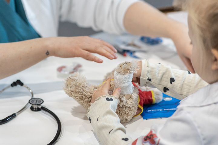 Lapsi hoitaa pehmolelua Nallesairaalassa.