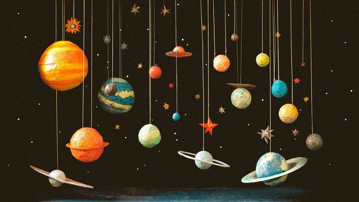 Miniatyyriplaneettoja ja tähtiä roikkuu tummalla taustalla, kuvaten avaruutta.