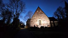 En stenkyrka upplyst mot en djupblå grund.