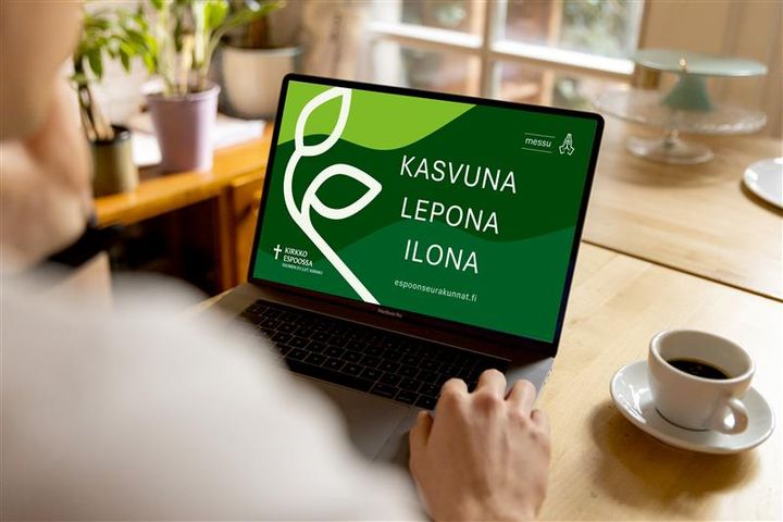 Kuvassa on kannettava tietokone pöydällä. Ruudulla teksti kasvuna lepona ilona. espoonseurakunnat.fi