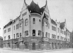 Vanha valokuva Tirkkosen talosta ja sen lisäsiivestä vuodelta 1906. Arkitehtien Lars Sonck ja Birger Federley suunnittelema koristeellinen rakennus, jossa on tornimaisia rakenteita ja suuria ikkunoita. Sijainti Kauppakatu 6, Kuninkaankatu 21.