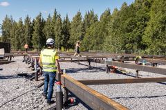 Rakennustyömaa metsätaustan edessä, työntekijöitä näkyvissä.