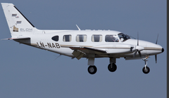 Ett litet, tvåmotorigt flygplan flyger på den blå himlen.