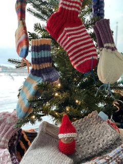 Erilaisia villasukkia roikkumassa joulukuusesta.