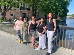 Fem kvinnor på Biblioteksbron i Åbo i vackert sommarväder med Aura å bakom sig.