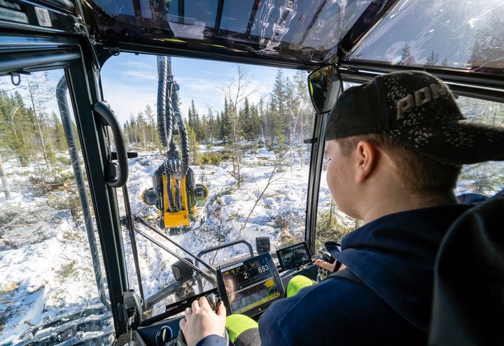 OSAOn metsäalan opiskelija kuvattuna metsäkoneen ohjaamossa.