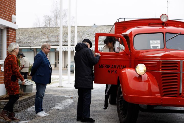 VPK on ollut Anna-Maijan ja hänen aviomiehensä yhteinen tärkeä harrastus. Juhlapäivänä tavanomaisesta poikkeavan työmatkan päätteeksi oven museoautosta avaakin luonnollisesti oma aviomies - Jorma Kenttä. Kunnanviraston pihalla vastassa on kunnanjohtaja Juha Vasama ja yksi pitkäaikaisimmista työtovereista - kunnasta jo aiemmin eläköitynyt palvelusihteeri Eija Alanen.