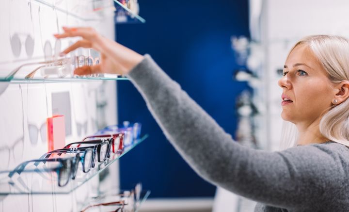 Nainen valitsee laseja optikkoliikkeessä.