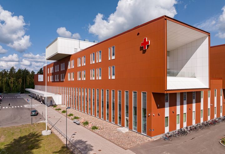 Ratamokeskuksen sairaalarakennus, jossa on valkoinen katto ja punainen risti -symboli yläkulmassa.