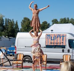 Kolme akrobaattia seisoo toistensa harteilla