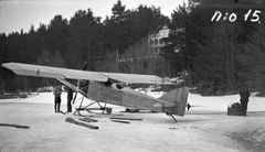 Mustavalkoinen kuva lentokoneen lentokokeista järven jäällä, Helkavuoren huvilan edustalla, vuodelta 1926.