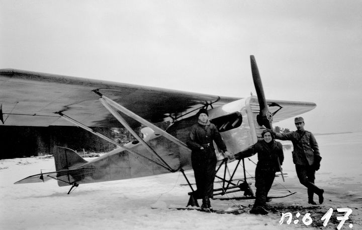 Kolme miestä seisoo lentokoneen vieressä Vanajaveden jäällä huhtikuussa 1926.