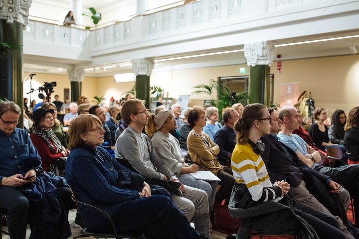 Yleisökuva, missä kolmessa rivissä istuu henkilöitä