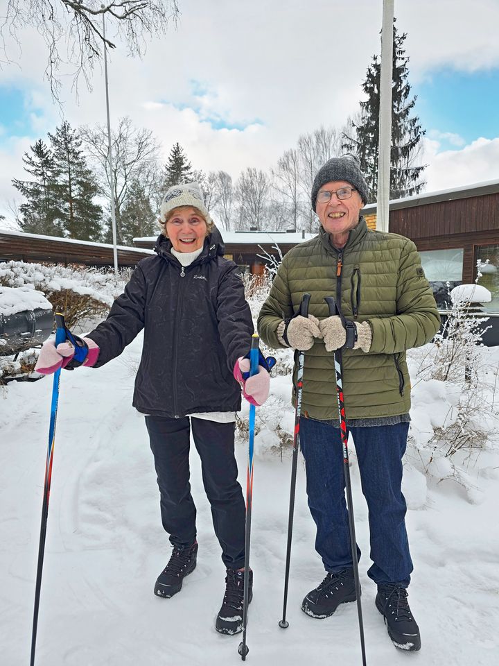 Anneli ja Matti seisovat ulkona kävelysauvojen kanssa.