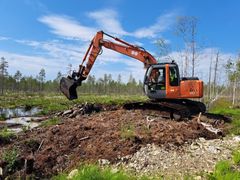 Kaivinkone kasasi patoja ojiin veden pidättämiseksi Iso-Piitsonsuon ennallistamiskohteessa Ilomantsissa Pohjois-Karjalassa.