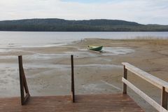 Näkymä Pielisen rannalta Ahvenisella. Etualalla laituri ja rannalla kanootti, taustalla metsäinen maisema.