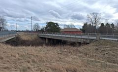 Silta, joka ylittää kuivuneen joenuoman, taustalla pilvinen taivas.